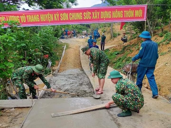 Cán bộ, chiến sĩ Ban CHQS huyện Kỳ Sơn phối hợp với các tổ chức, đoàn thể giúp người dân xã Hữu Lập làm đường giao thông.