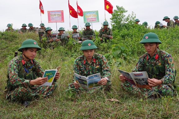 Cán bộ, chiến sĩ Trung đoàn 141 đọc báo trong giờ nghỉ giao lao trên thao trường. (Ảnh chụp trước ngày 27-4-2021)